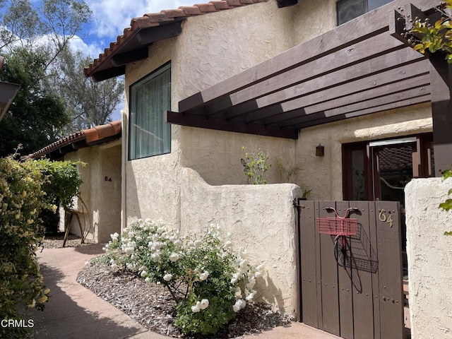 205 Pirie Rd Unit 64, Ojai, CA 93023 - view of side of property with a gate, stucco siding, and a tile roof