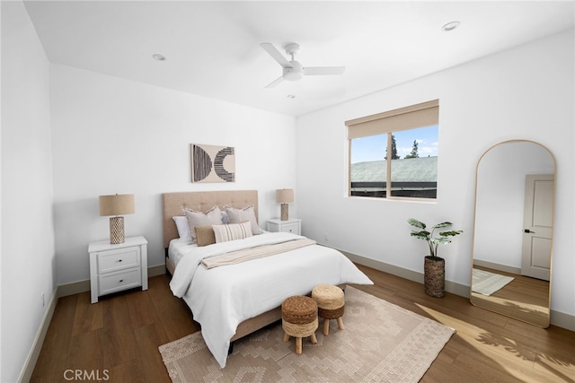 bedroom featuring a ceiling fan, wood finished floors, recessed lighting, arched walkways, and baseboards