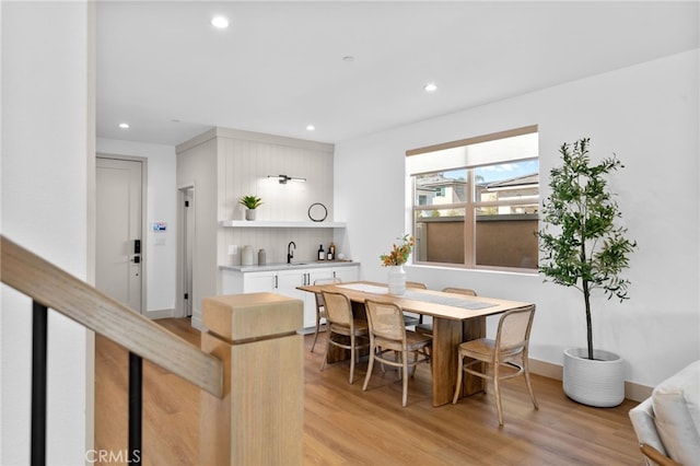 dining room with baseboards, light wood finished floors, and recessed lighting