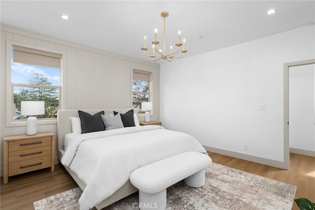 bedroom with recessed lighting, baseboards, a notable chandelier, and wood finished floors