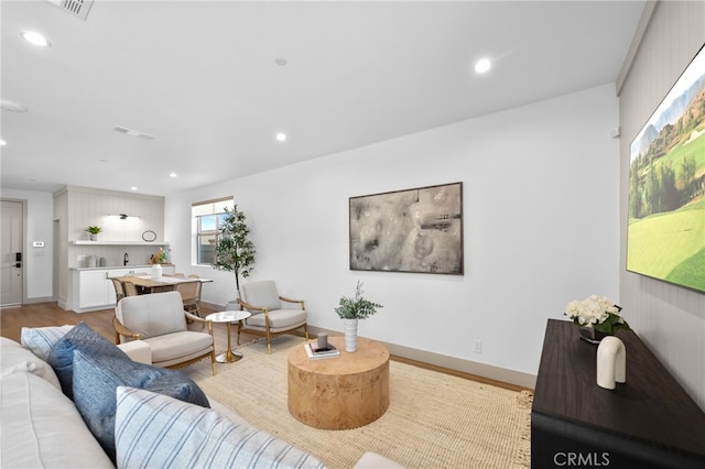 living area featuring recessed lighting, visible vents, light wood finished floors, and baseboards