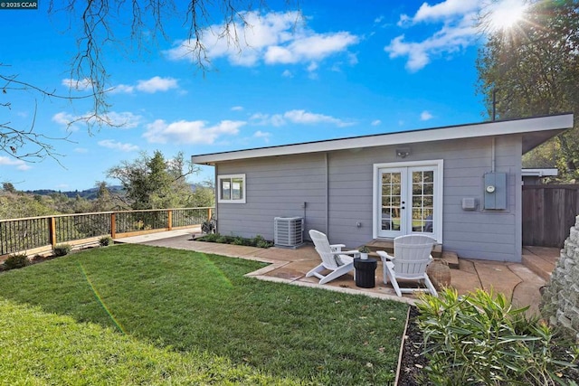 back of house featuring a yard, central AC, a patio, an outdoor fire pit, and french doors