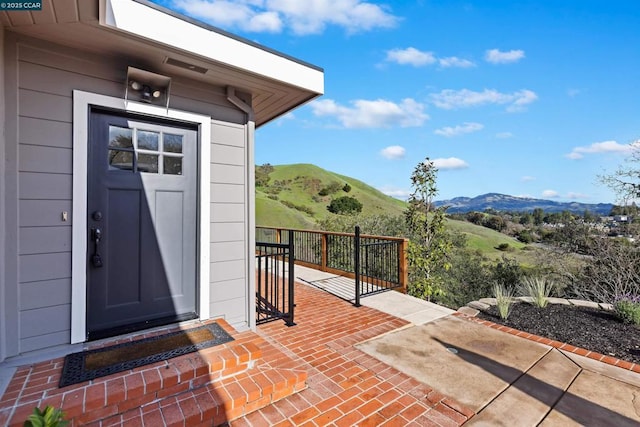 entrance to property with a mountain view and a patio