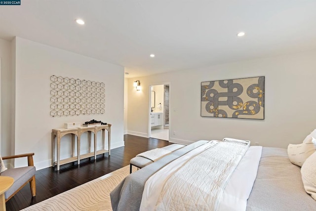 bedroom with connected bathroom and dark hardwood / wood-style flooring