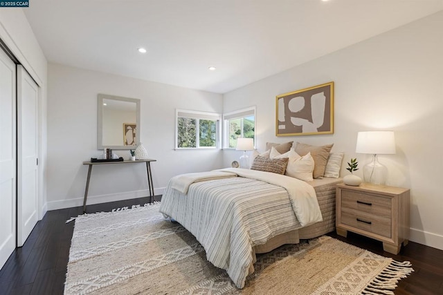 bedroom with dark hardwood / wood-style flooring and a closet