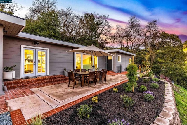 patio terrace at dusk featuring french doors