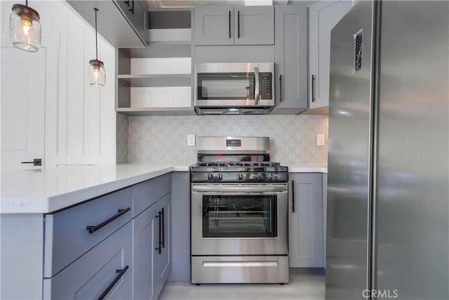 kitchen featuring stainless steel appliances, gray cabinetry, pendant lighting, and backsplash