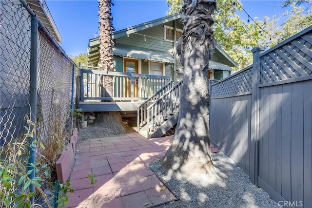 back of house with a wooden deck and a patio area