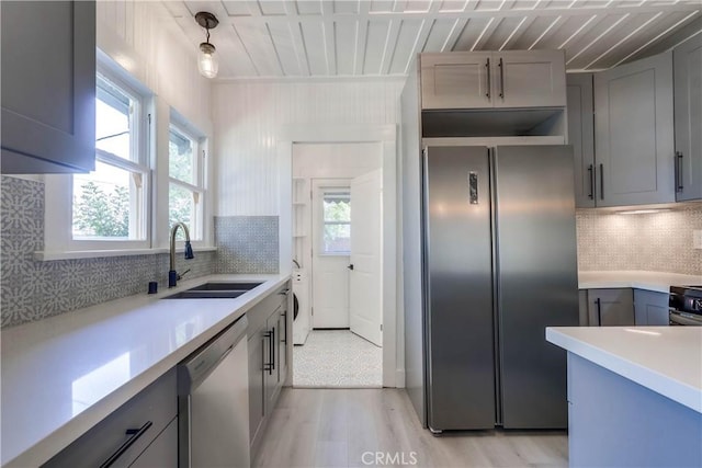 kitchen featuring pendant lighting, sink, gray cabinets, and appliances with stainless steel finishes