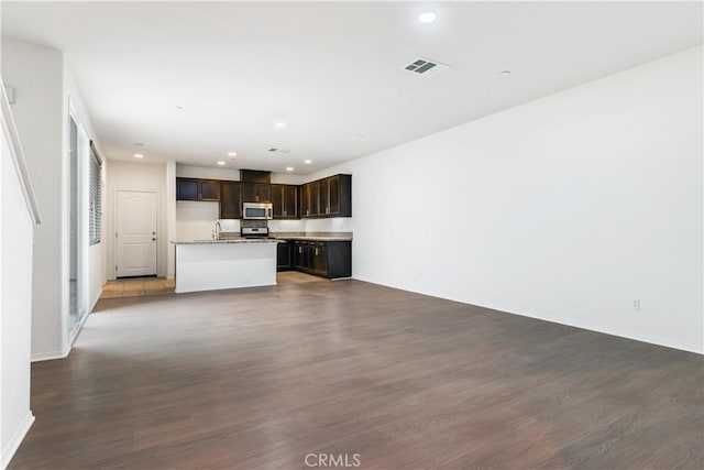 unfurnished living room featuring sink and dark wood-type flooring