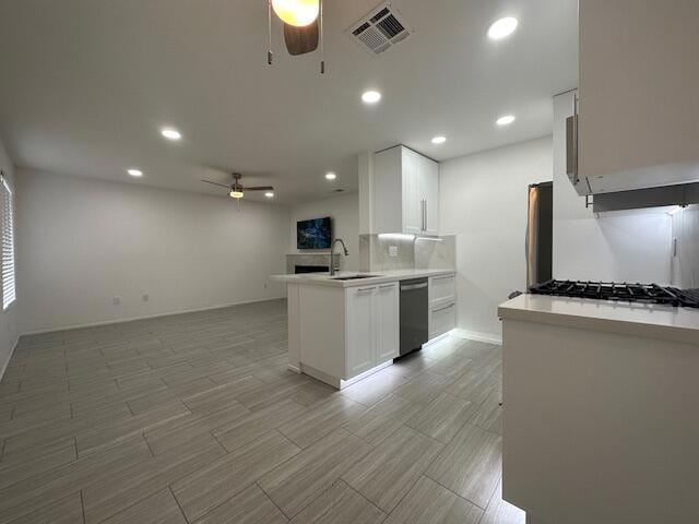 kitchen with white cabinetry, sink, ceiling fan, kitchen peninsula, and stainless steel appliances