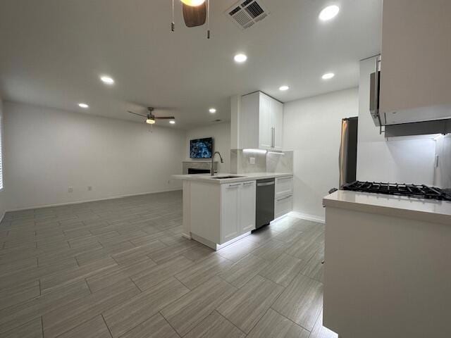 kitchen featuring sink, white cabinetry, kitchen peninsula, ceiling fan, and stainless steel appliances