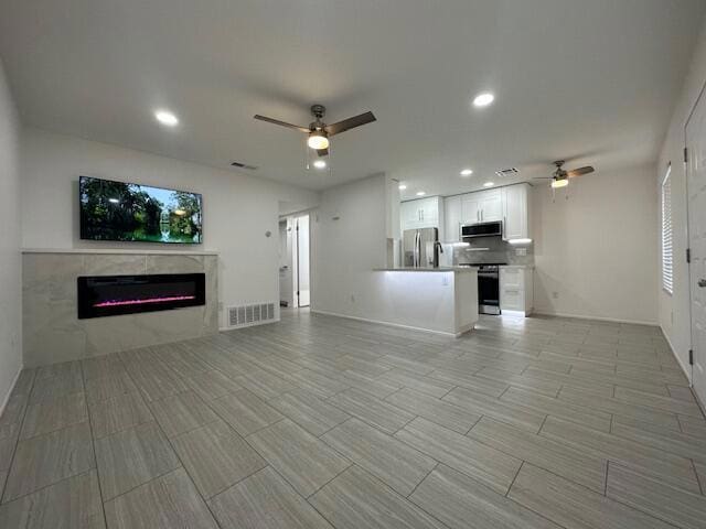 unfurnished living room with ceiling fan