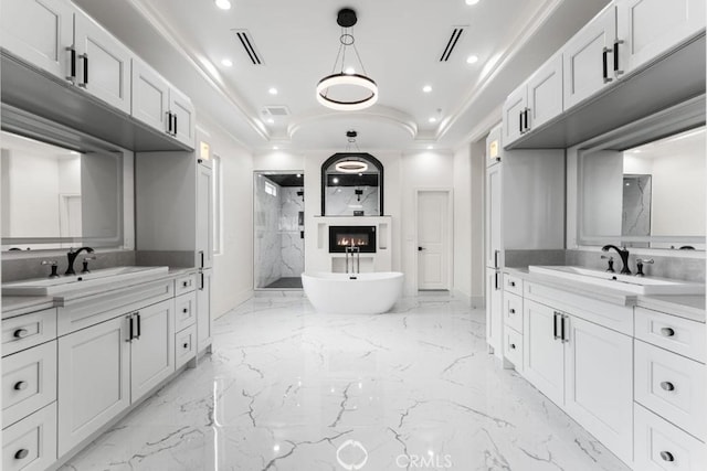 bathroom with crown molding, vanity, a tray ceiling, and separate shower and tub