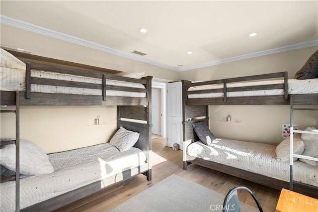 bedroom with ornamental molding and light wood-type flooring