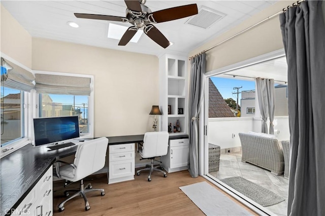 office with light hardwood / wood-style flooring and ceiling fan