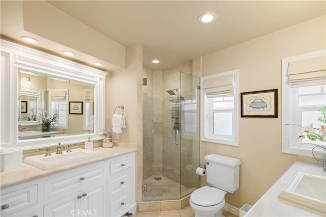 bathroom with vanity, toilet, and a shower with shower door