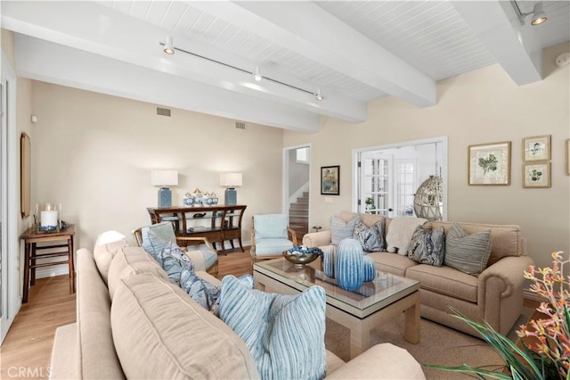 living room featuring french doors, track lighting, beam ceiling, and light hardwood / wood-style flooring