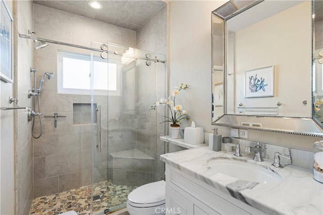 bathroom featuring vanity, toilet, and walk in shower