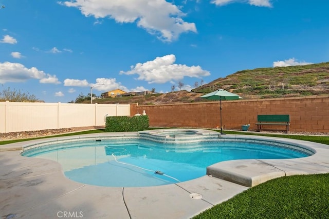 view of swimming pool with an in ground hot tub