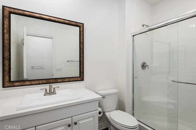 bathroom with a shower with door, vanity, and toilet