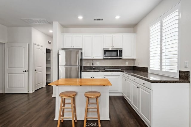 kitchen with appliances with stainless steel finishes, sink, and white cabinets