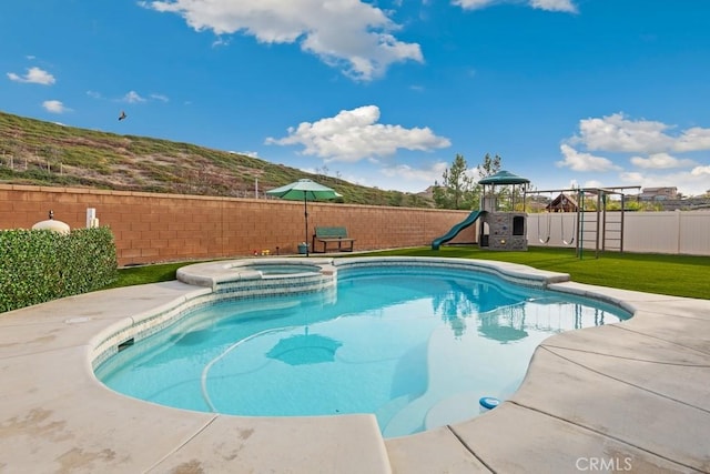 view of swimming pool with a yard, a playground, and an in ground hot tub