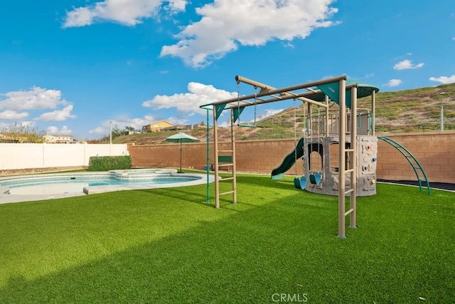 view of play area featuring a fenced in pool and a lawn