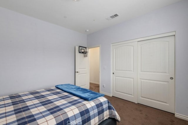 bedroom featuring a closet and dark colored carpet