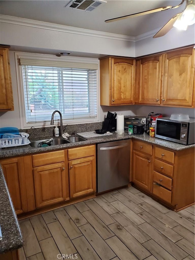 kitchen featuring sink, ornamental molding, stainless steel appliances, and ceiling fan