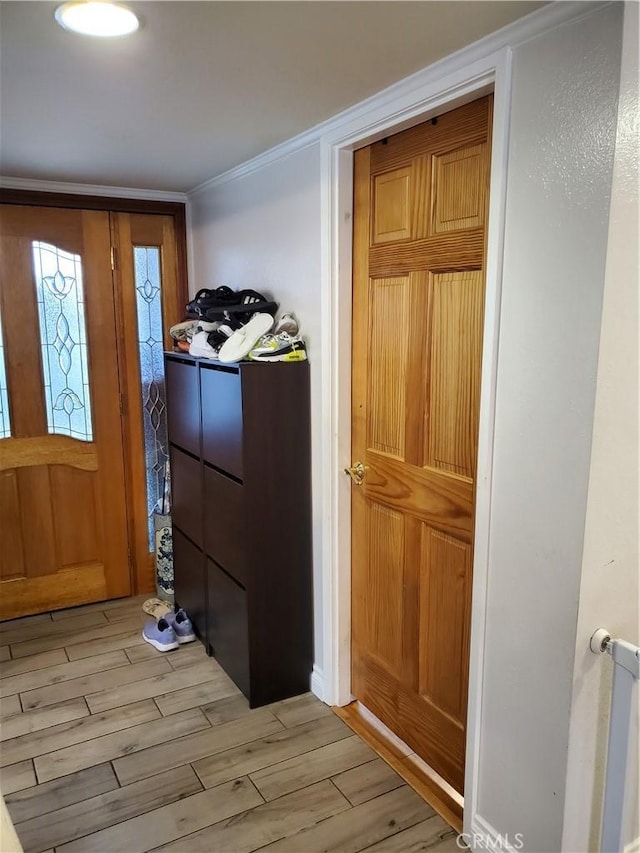 interior space featuring ornamental molding and light wood-type flooring