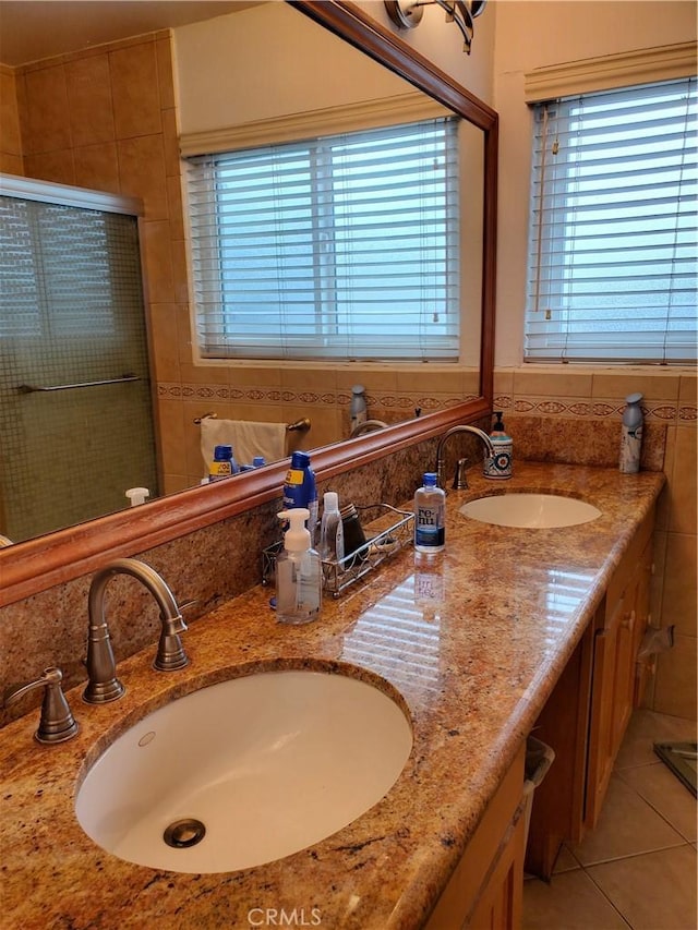 bathroom featuring tile patterned flooring, vanity, and a shower with shower door