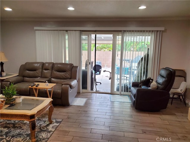 living room with crown molding and light wood-type flooring