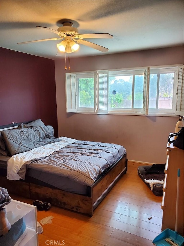 bedroom with ceiling fan and light hardwood / wood-style flooring