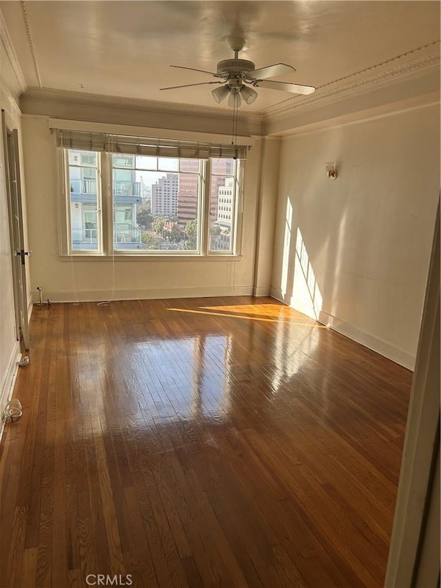 empty room with ceiling fan, ornamental molding, and dark hardwood / wood-style flooring