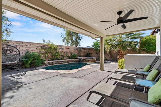 view of patio / terrace with ceiling fan and a swimming pool with hot tub