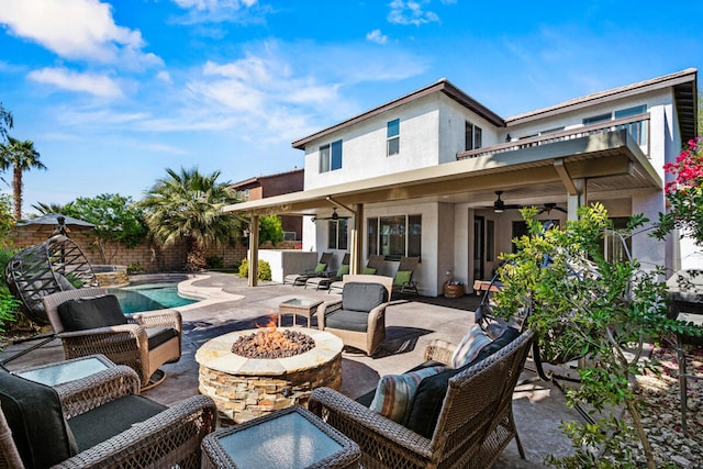 view of patio / terrace with a fenced in pool, an outdoor living space with a fire pit, and ceiling fan