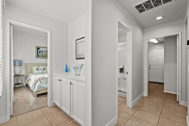 hallway with light tile patterned floors and a baseboard radiator