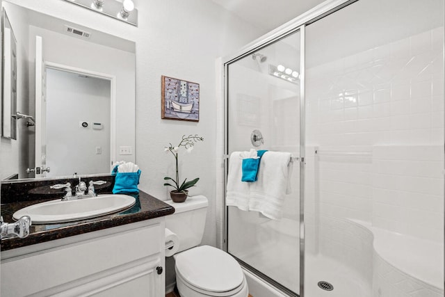 bathroom featuring vanity, toilet, and walk in shower