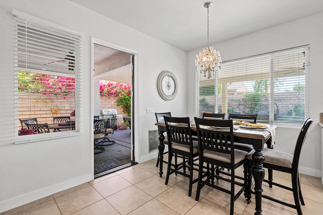 tiled dining room with a chandelier