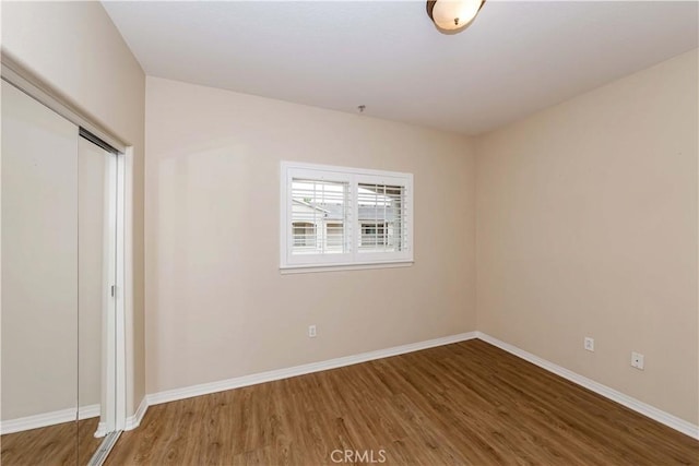 unfurnished bedroom with hardwood / wood-style flooring and a closet