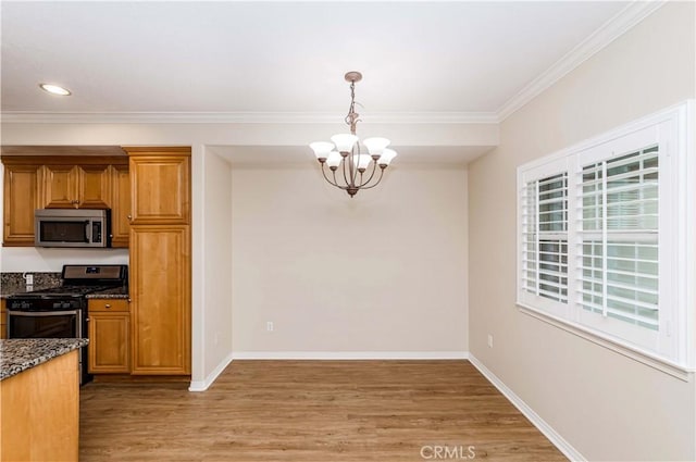 kitchen featuring decorative light fixtures, dark stone countertops, stainless steel appliances, an inviting chandelier, and light hardwood / wood-style flooring