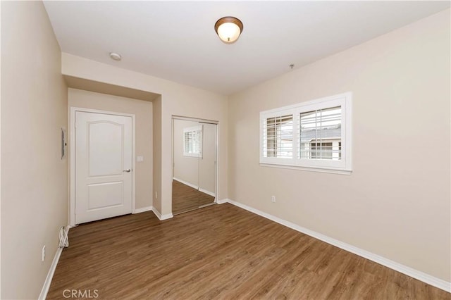 unfurnished bedroom featuring dark wood-type flooring and a closet