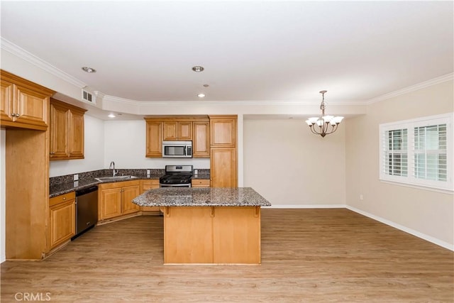 kitchen featuring stainless steel appliances, a center island, sink, and light wood-type flooring