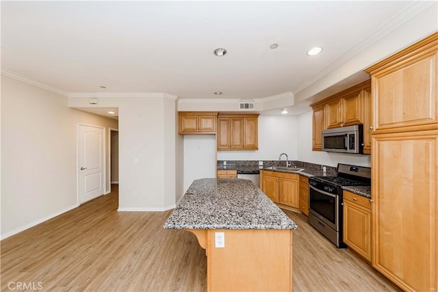 kitchen featuring stone counters, a kitchen island, appliances with stainless steel finishes, sink, and a kitchen breakfast bar