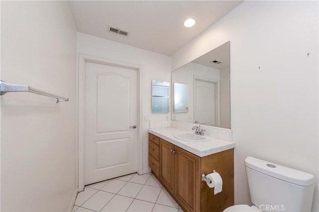 bathroom with tile patterned flooring, vanity, and toilet