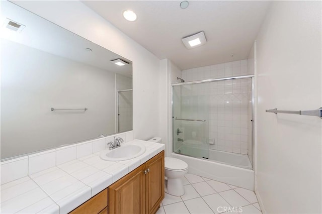 full bathroom with tile patterned flooring, enclosed tub / shower combo, vanity, and toilet