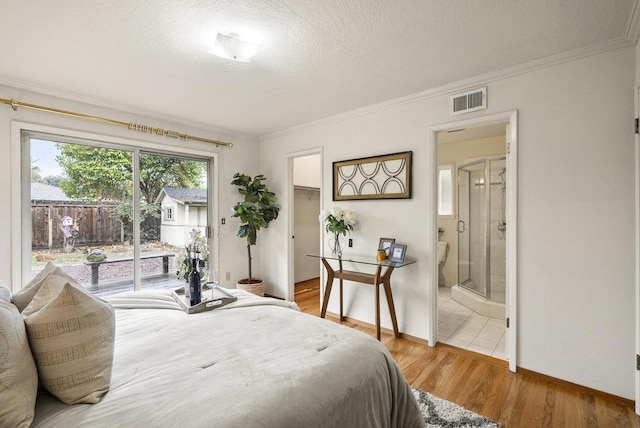 bedroom with hardwood / wood-style floors, access to outside, ornamental molding, and a textured ceiling