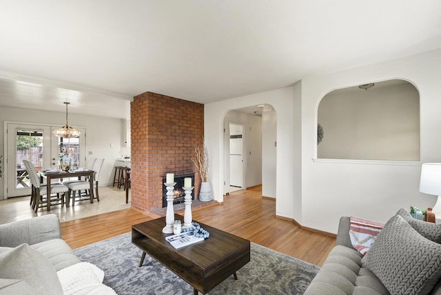 living room featuring a notable chandelier and light wood-type flooring