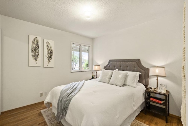 bedroom with hardwood / wood-style flooring and a textured ceiling